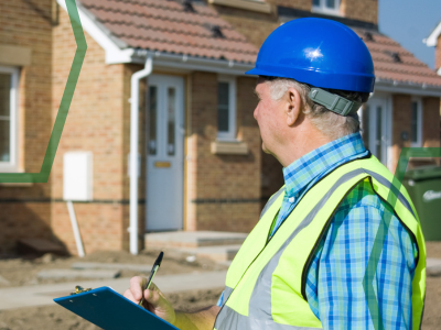 A picture showing a man in a hardhat and high viz jacket. He is a damp surveyor looking at a home.